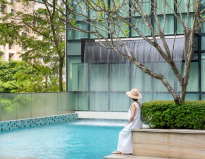 Lady Sitting By The Swimming Pool at Park Regis by Prince Singapore